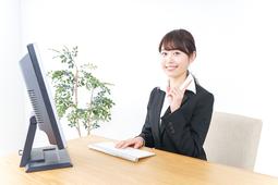 パソコンの前で座っている事務の女性